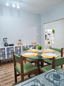 een eetkamer met een tafel en groene stoelen bij Casa ampla e confortável in Garanhuns