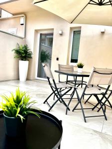 a patio with two chairs and a table with plants at Casa Lina in Punta Secca