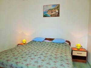 a bedroom with a bed with blue pillows on it at Apartment Koric in Ičići