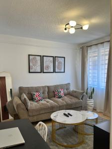 a living room with a couch and a table at Tranquil Luxury Stay, Utawala, JKIA View in Nairobi