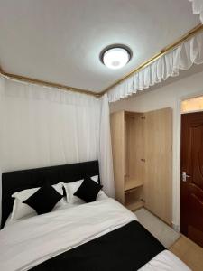 a bedroom with a bed with black and white pillows at Tranquil Luxury Stay, Utawala, JKIA View in Nairobi