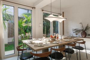 un tavolo da pranzo con sedie e una grande finestra di Private Pool, 8-Bedroom, Old Town, Entire Estate - TANPURI Thapea - Prime Location a Chiang Mai
