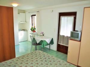a room with a bed and a table and a kitchen at Apartment Koric in Ičići