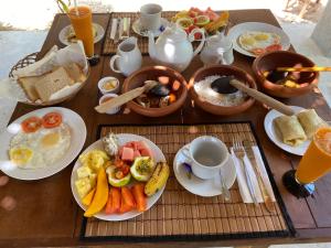 a table with a breakfast of eggs and fruits and vegetables at The Dale Mirissa in Mirissa +38 photos