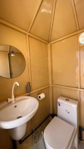 a small bathroom with a sink and a toilet at Dome private camp 1 in Al Raka