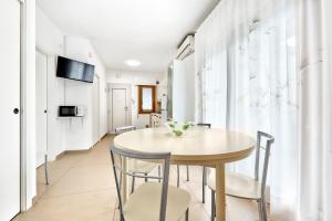 a dining room with a table and chairs at Jesolo Sun Beach House - Host Solution in Lido di Jesolo