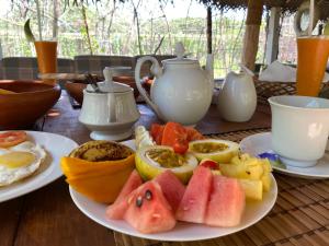 a plate of fruit on a table with tea pots at The Dale Mirissa in Mirissa