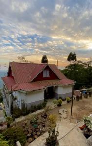 a red and white house with a red roof at Máple farmstay in Darjeeling