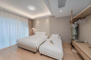 a bedroom with two beds and a window at 苏州山塘街华贸姑苏里酒店公寓 in Suzhou