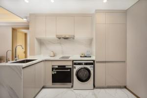 a white kitchen with a dishwasher and a sink at 苏州山塘街华贸姑苏里酒店公寓 in Suzhou