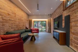 a living room with a green couch and a brick wall at Mahavan Resort in Chitrod