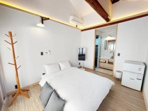 a bedroom with a white bed and a tv at Hanokstay mokhwa in Gyeongju