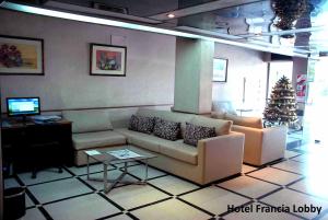 a living room with a couch and a christmas tree at Hotel Francia in San Miguel de Tucumán