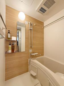 a bathroom with a tub and a mirror at Celine Kanayama Building in Hiroshima