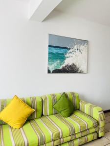 un sofá verde en una habitación con una pintura en la pared en Frere Hill Guesthouse, en Durban