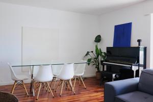 a living room with a glass table and a piano at Luxury Condo in Setúbal in Setúbal