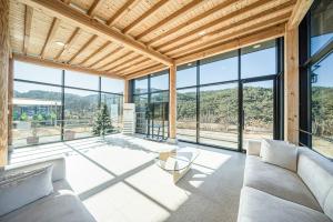 a living room with a couch and a table and windows at Gyeongju Davulchon Pension in Gyeongju
