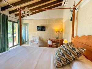 a bedroom with a white bed and a desk at Finca Son Pont in Puigpunyent