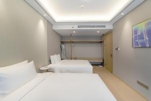 a hotel room with two beds and a projection screen at 苏州山塘街华贸姑苏里酒店公寓 in Suzhou