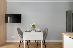 Televízia a/alebo spoločenská miestnosť v ubytovaní Jasny & Elegancki Apartament typu Studio z Tarasem by Noclegi Renters + 35 fotografií
