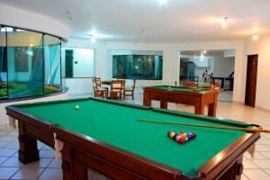 a pool table in a living room with a pool table at Sueds Plaza in Porto Seguro