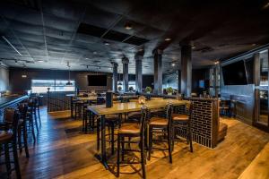 a restaurant with tables and chairs and a bar at Hotel Lex and Conference Center, Trademark Collection in Lexington