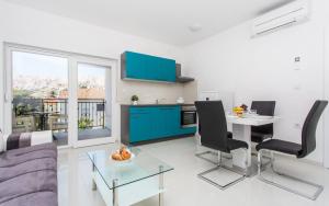 a kitchen and living room with a table and chairs at Apartments Bernardeta 1 in Baška