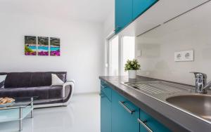 a kitchen with a sink and a couch at Apartments Bernardeta 1 in Baška +91 photos
