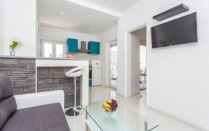 a living room with a glass table and a tv at Apartments Bernardeta 1 in Baška