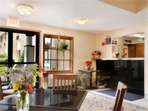 a living room with a glass table with flowers on it at Days Inn by Wyndham Keene NH in Keene