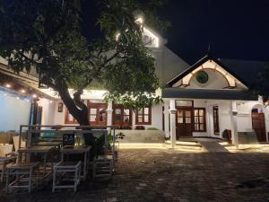 a building with chairs and a tree in front of it at Domore Lifestyle in Yogyakarta