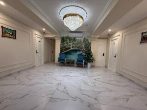 a large hallway with a chandelier and a large marble floor at Beksaroy in Samarkand