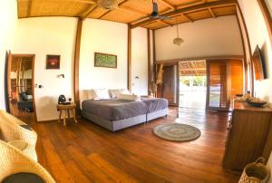 a bedroom with a bed and a wooden floor at Baha Baha Villa Sailo Hts Mentawai Hollow Trees in Katiet +111 photos