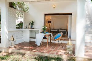 a patio with a table and chairs on a brick floor at Mawimbi Studio in Galu