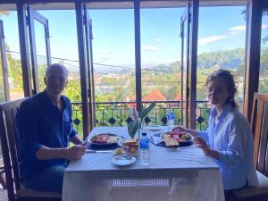 a man and a woman sitting at a table with food at Sesatha lake Kandy in Kandy