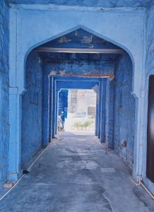 焦特布尔Tiny Home Jodhpur - A studio apartment的建筑中带有拱门的蓝色走廊