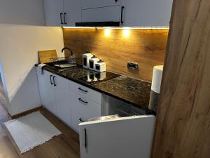 a kitchen with white cabinets and a counter top at DW Szarotka in Białka Tatrzanska