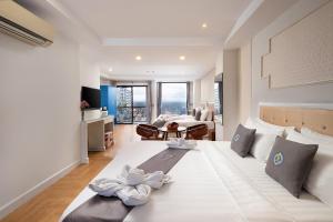 クロン・ポイペトにあるHak Huot Hotel Iのベッドルーム(花の飾られた白い大型ベッド付)