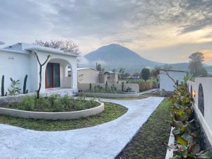 a white house with a mountain in the background at Alaya at volcano in Baturaja