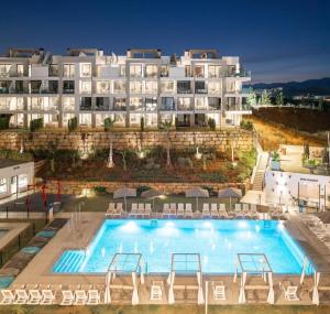 a hotel with a large swimming pool in front of a building at De Droomhacienda in Fuengirola