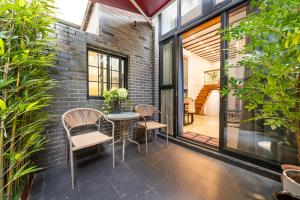 上海Tonight Aparthotel Jing'an Temple Branch Shanghai的一个带桌椅和砖墙的庭院