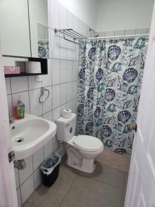 Un baño con inodoro, lavabo y cortina de ducha. en Casa frente al lago, en Sacramento
