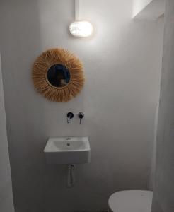 bagno con lavandino, specchio e servizi igienici di The Rabbit Hole Hostel Fira a Firà Altre 37 foto