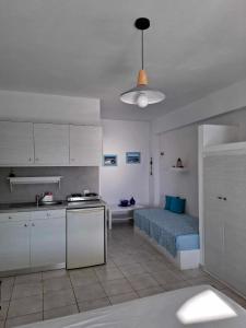 a kitchen and a bedroom with a bed in a room at Vrahos Rooms - Studios in Alopronia