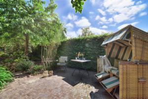 ein Garten mit einem Tisch und einem Stuhl und einem Zaun in der Unterkunft Kapitäns Hus Ferienhaus Avantgarde in Putbus