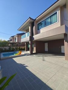 a large house with a swimming pool in front of it at aSU villa in Ban Huai Yai