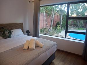 a bedroom with a bed with two towels on it at MBCholidayhouse in Cape Town