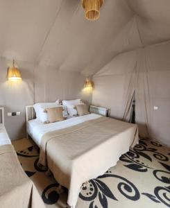 a bedroom with a large bed in a tent at Merzouga Desert Campsite &Activities in Merzouga