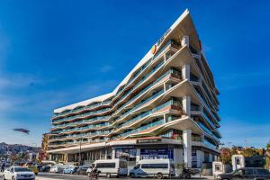 a large building with cars parked in a parking lot at Benesta Guest Teori in Istanbul