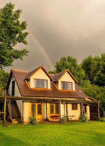 a rainbow in the sky above a house at Ebernburg Cottage in Nottingham Road